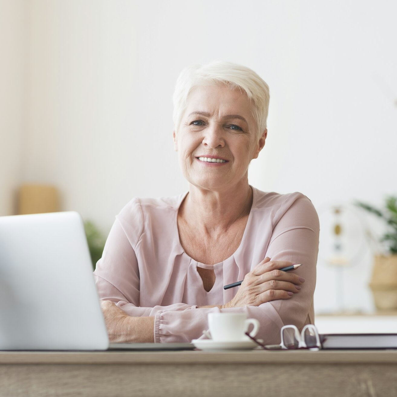 Attractive old lady posing at workdesk at home